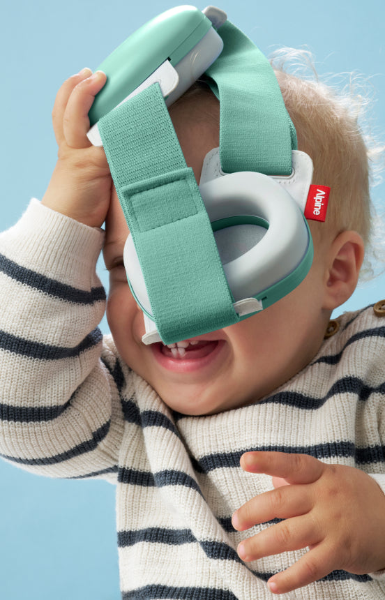 baby haelt muffy baby neu in gruen in der hand